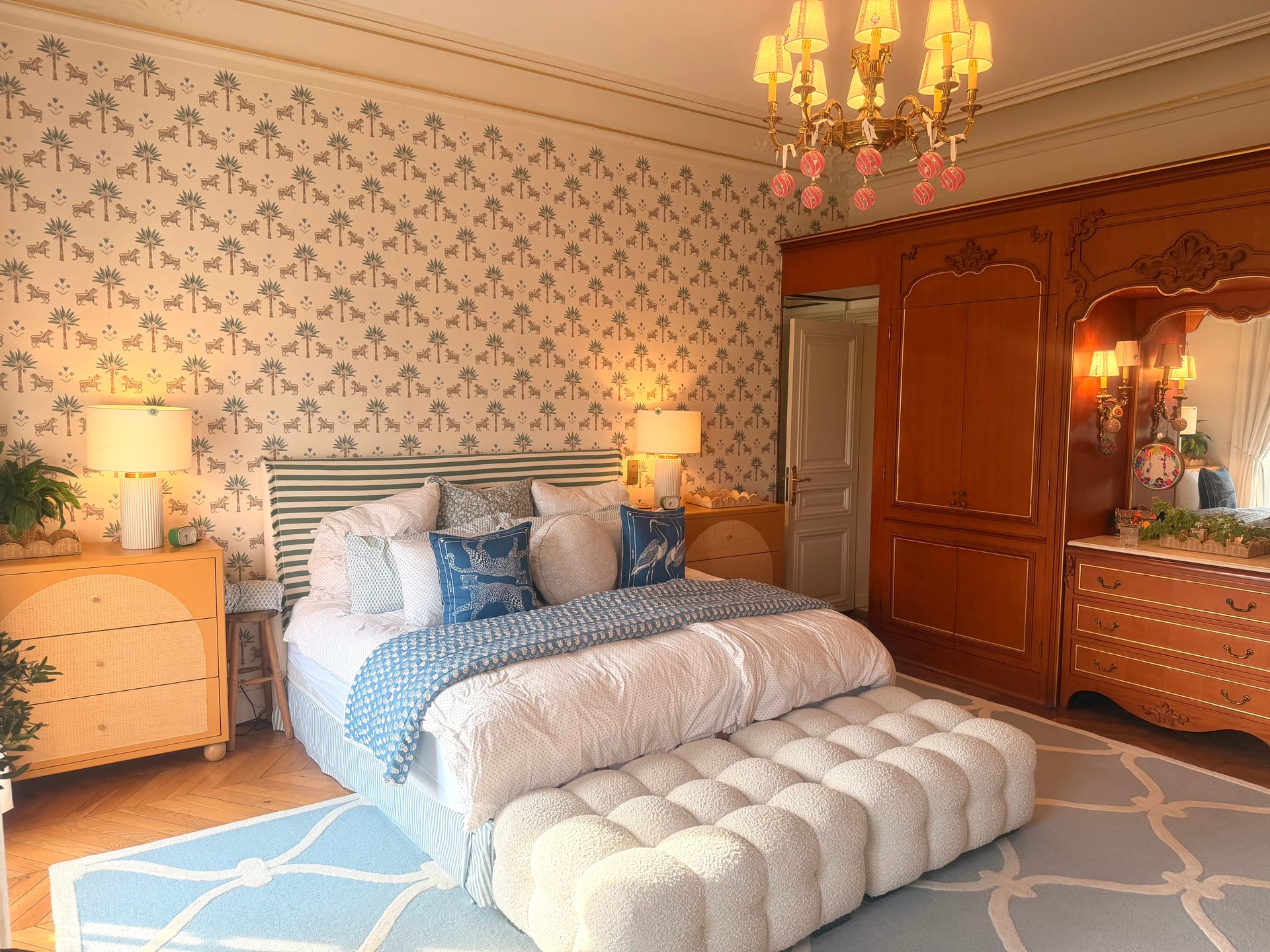 Master suite wide — bed, soft bench and the armoire
